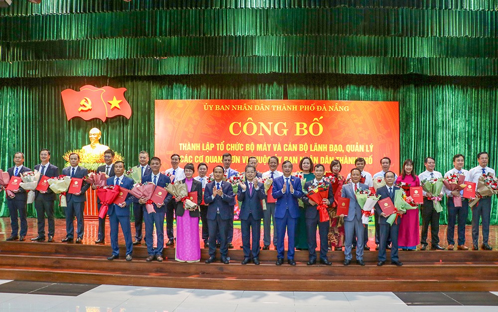 Lãnh đạo thành phố Đà Nẵng trao quyết định và tặng hoa cho các cá nhân được điều động bổ nhiệm (Ảnh danang.gov)