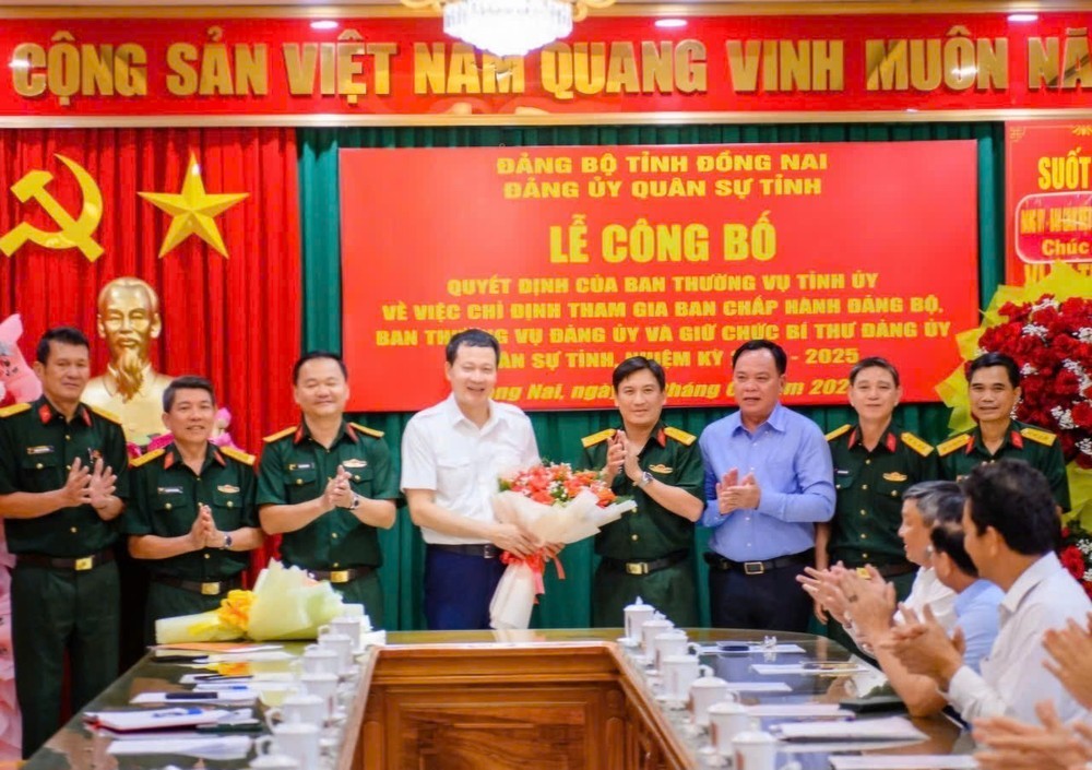 Phó bí thư thường trực Tỉnh ủy Hồ Thanh Sơn trao quyết định và tặng hoa chúc mừng Bí thư Tỉnh ủy Vũ Hồng Văn, Bí thư Đảng ủy Quân sự tỉnh. (Ảnh: Công Nghĩa)