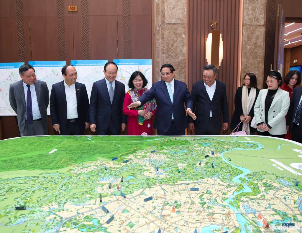 Thủ tướng Chính phủ Phạm Minh Chính, Bí thư Thành ủy Hà Nội Bùi Thị Minh Hoài cùng các đồng chí lãnh đạo thành phố Hà Nội xem sa bàn điều chỉnh quy hoạch chung Thủ đô Hà Nội đến năm 2045, tầm nhìn đến năm 2065.