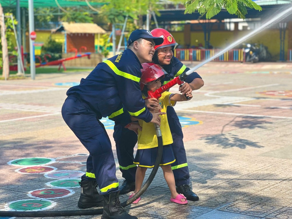 Các em được hướng dẫn thực hành phun nước chữa cháy. 