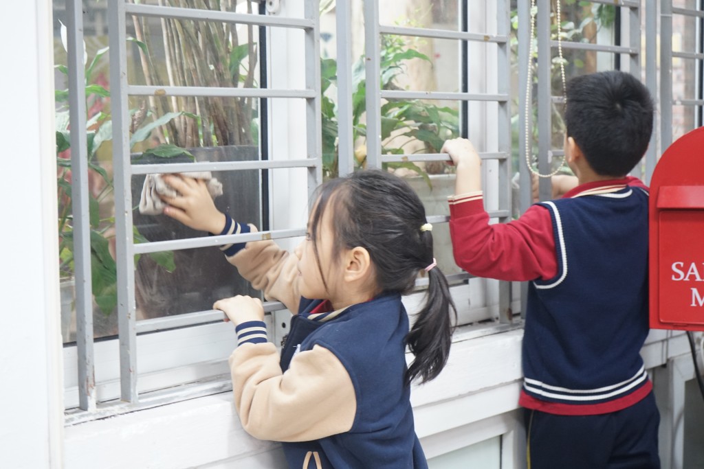 Các em học sinh cùng dọn dẹp lớp học 