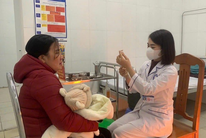 Tiêm vắc xin phòng bệnh cho trẻ tại trạm y tế xã.