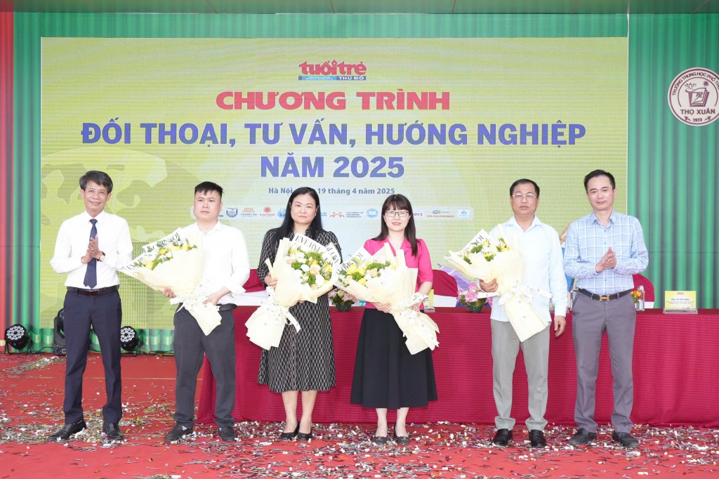 Phó Tổng biên tập Báo Tuổi trẻ Thủ đô Ngô Vương Tuấn, Hiệu trưởng Trường THPT Thọ Xuân tặng hoa các diễn giả tham gia chương trình