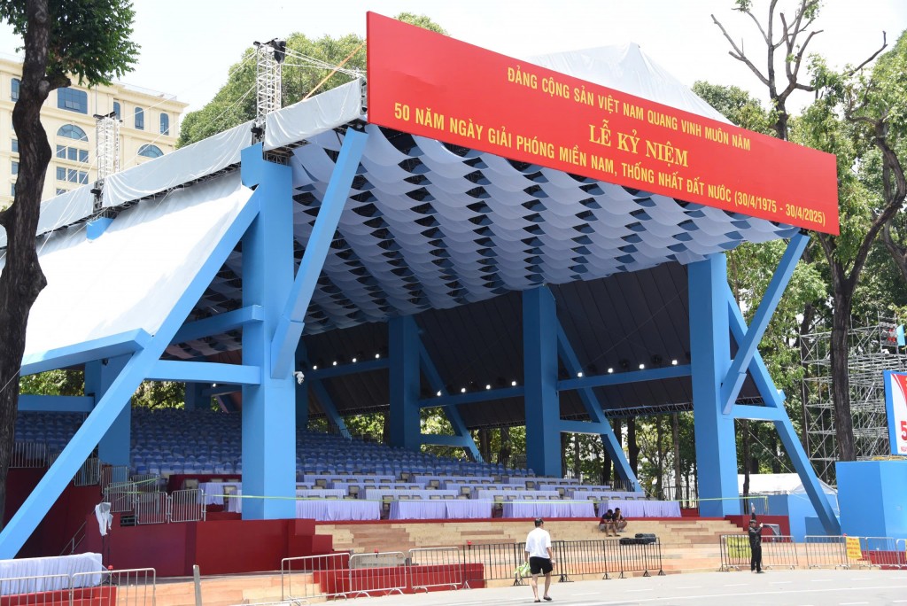 Một mái che lớn bằng vải bạt được dựng lên thành khu đón tiếp đại biểu. Những hàng ghế ngồi được lắp đặt bằng các tấm ván gỗ vững chắc. Phần mái được phủ bằng lụa xanh xếp lớp mềm mại, tạo nên những đợt sóng uốn lượn mỗi khi gió thoảng, vừa nghệ thuật vừa trang trọng. Một mái che lớn bằng vải bạt được dựng lên thành khu đón tiếp đại biểu. Những hàng ghế ngồi được lắp đặt bằng các tấm ván gỗ vững chắc. Phần mái được phủ bằng lụa xanh xếp lớp mềm mại, tạo nên những đợt sóng uốn lượn mỗi khi gió thoảng, vừa nghệ thuật vừa trang trọng.