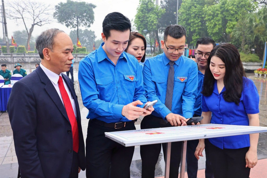 Bí thư Thành đoàn Hà Nội Chu Hồng Minh; Phó Bí thư Thành đoàn, Chủ tịch Hội đồng Đội thành phố Hà Nội Đào Đức Việt (thứ hai từ trái sang) cùng các đại biểu trải nghiệm quét mã QR trong số hóa di tích