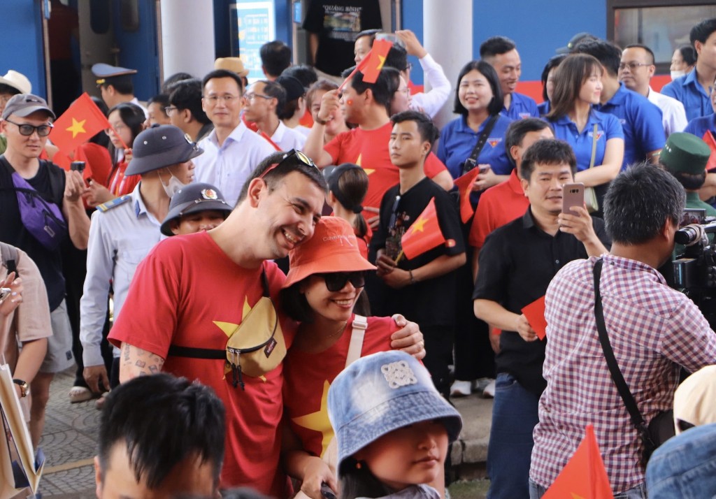 Du khách nước ngoài bày tỏ tình yêu đối với Việt Nam bằng cách mặc áo in hình cờ đỏ sao vàng xuống ga Đà Nẵng (Ảnh Đ.Minh)