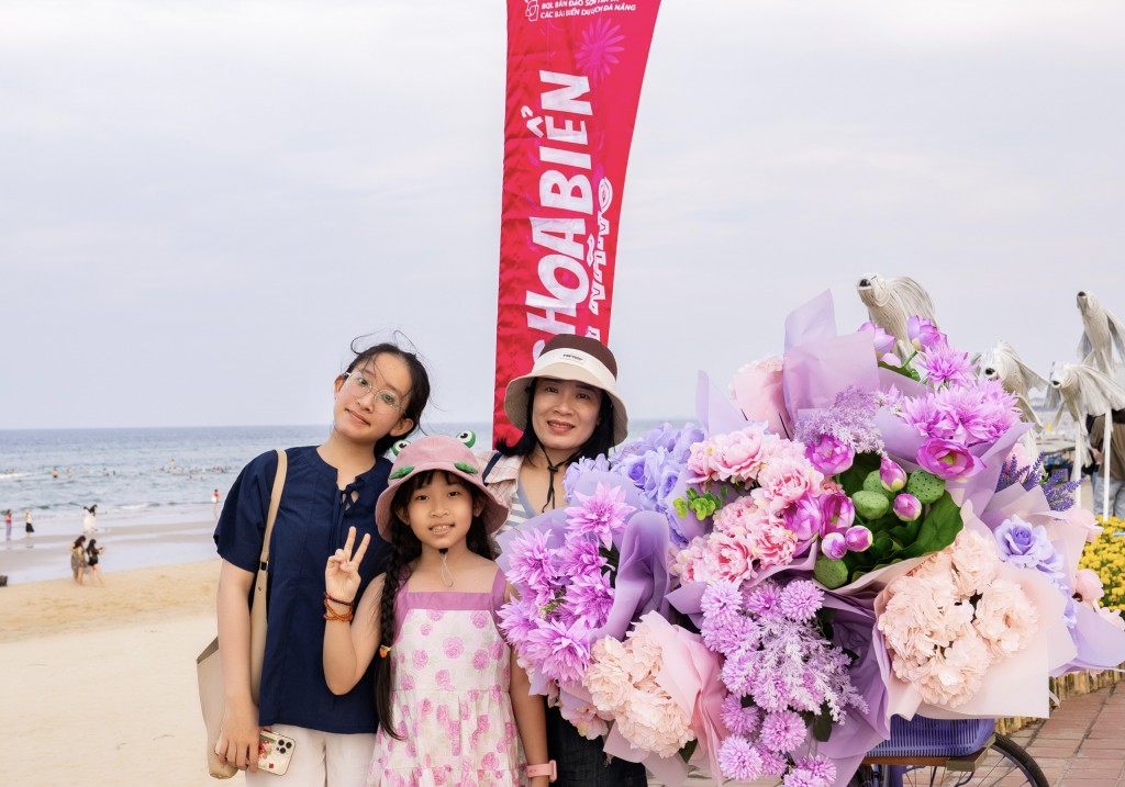 Du khách chụp ảnh check-in tại điểm trang trí đường hoa ven biển (Ảnh Đ.Minh)