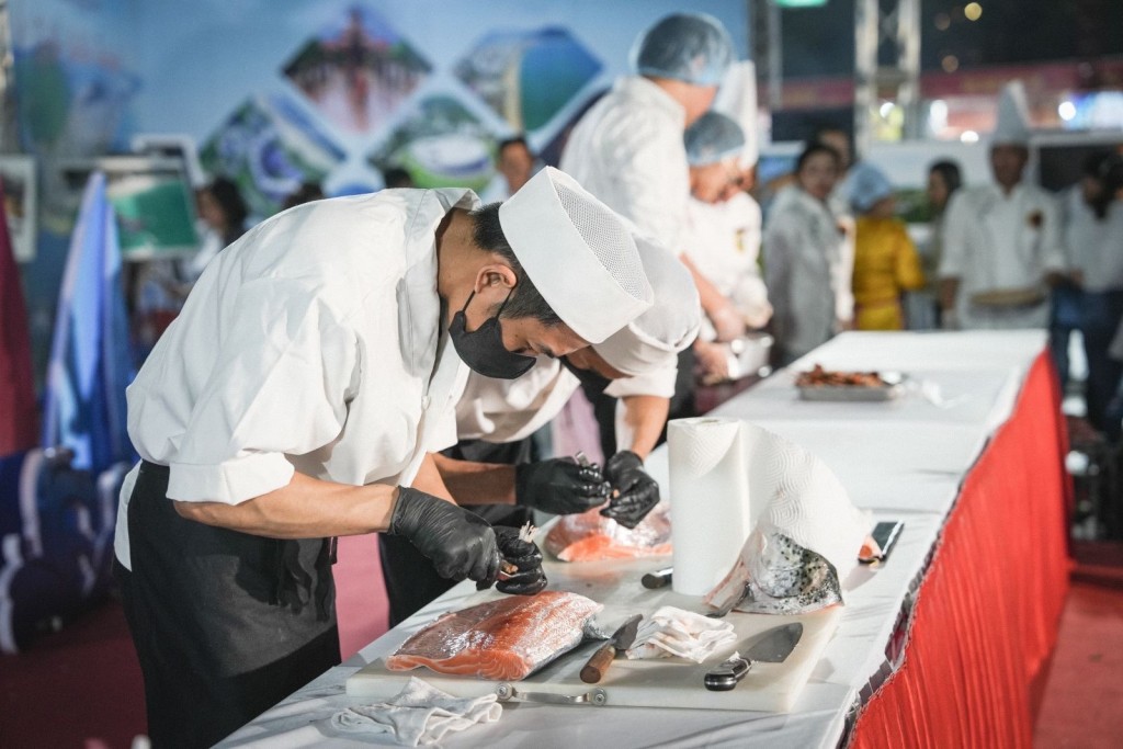 Các đầu bếp đến chế biến món cá hồi Sashimi tại chương trình (Ảnh binhdinh.gov)