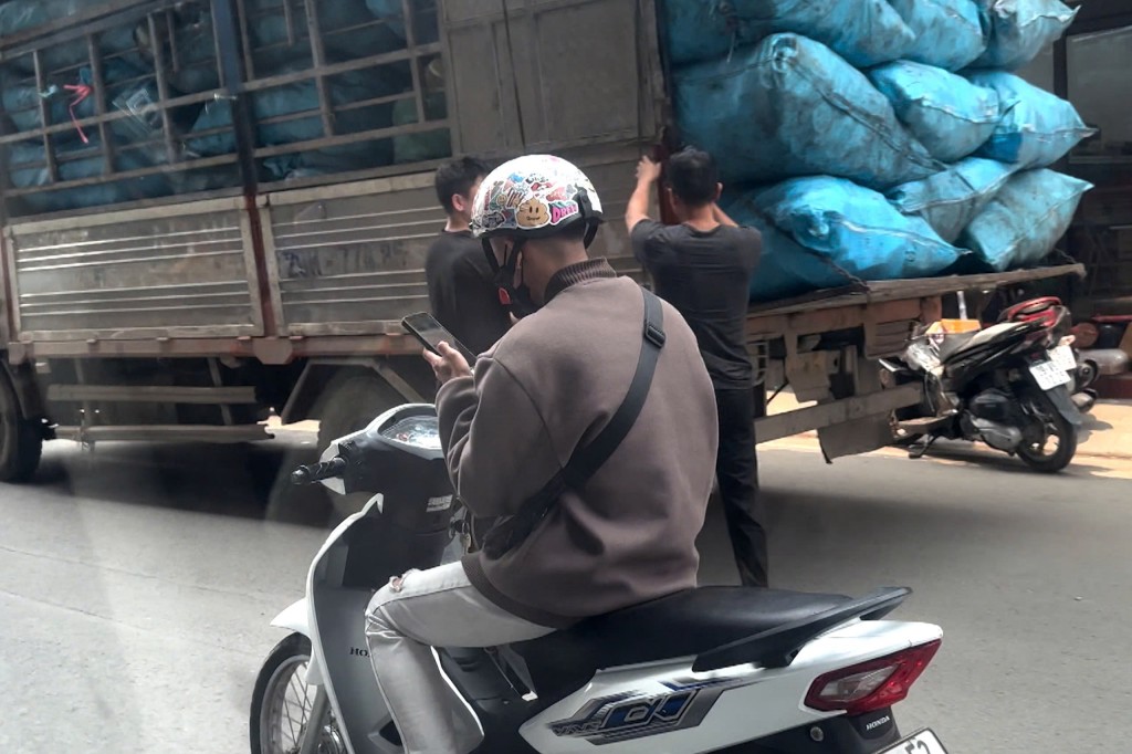 Người điều khiển xe máy vừa lái xe vừa gọi điện thoại trên phố Nguyễn Thái Học (Ba Đình, Hà Nội) giờ cao điểm