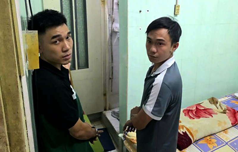 Hai đối tượng được cảnh sát áp giải thực nghiệm hiện trường vụ cướp