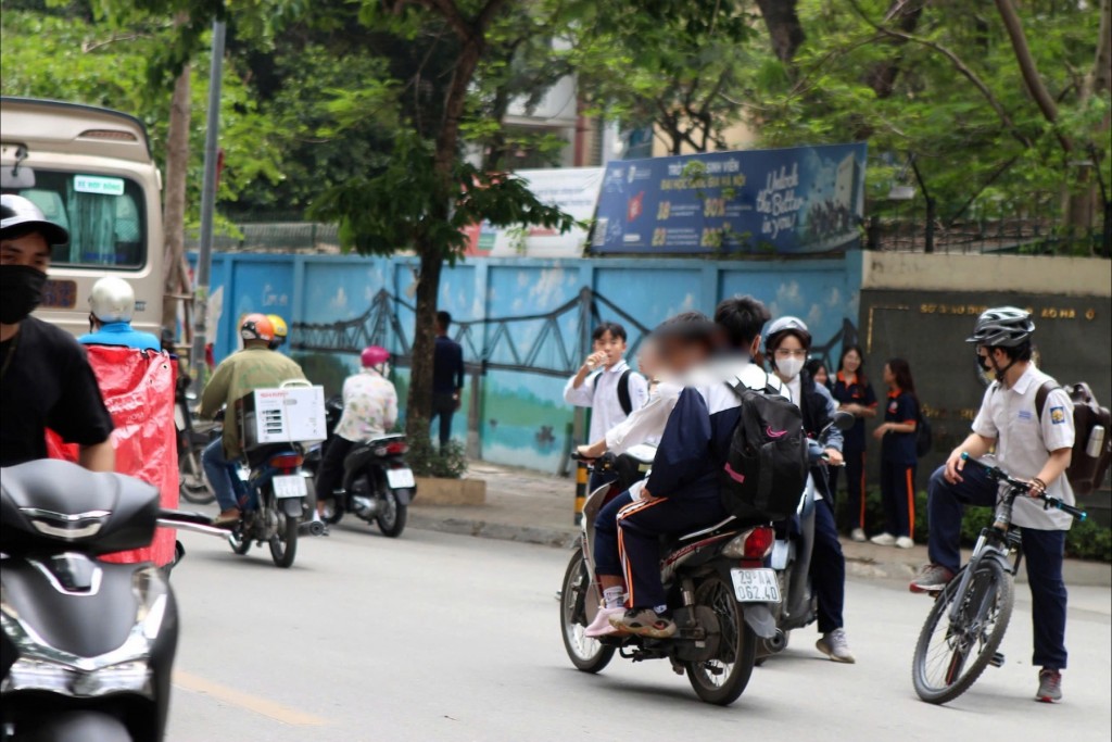 Không ít cha mẹ mua xe điện cho con nhưng không nhắc nhở, không quản lý việc đội mũ bảo hiểm (ghi nhận tại trường THPT dân lập Văn Lang, Đống Đa, Hà Nội)