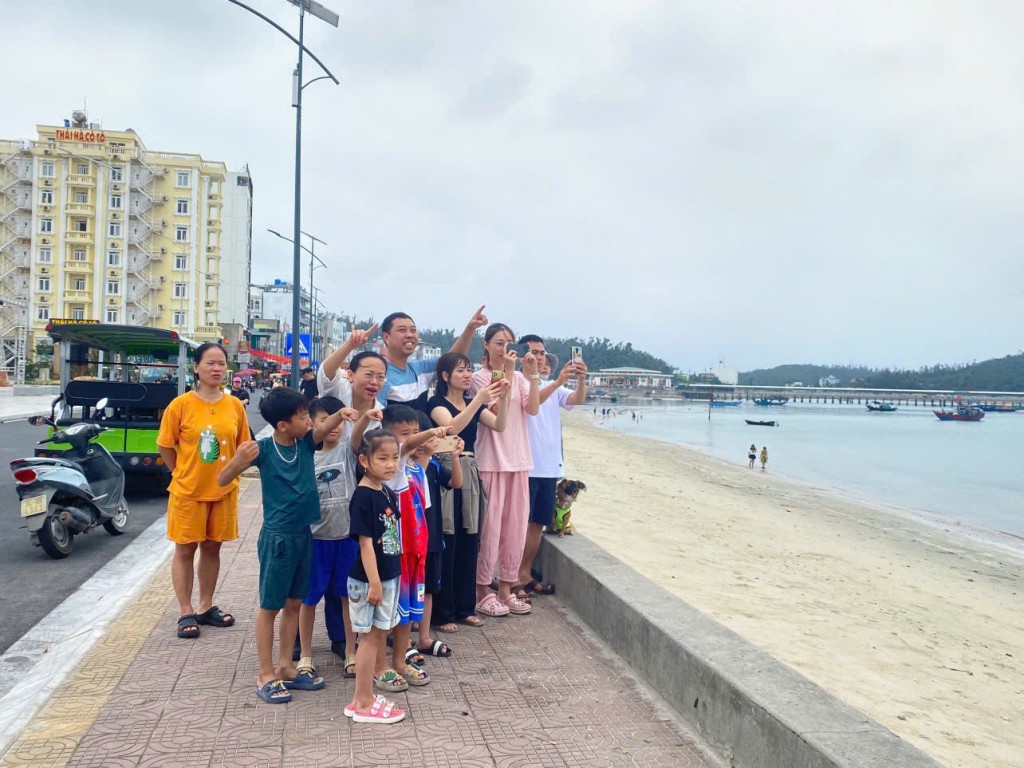 Bà Lê Ngọc Hân (áo trắng), Bí thư, Chủ tịch UBND huyện Cô Tô cùng nhân dân theo dõi dù lượn