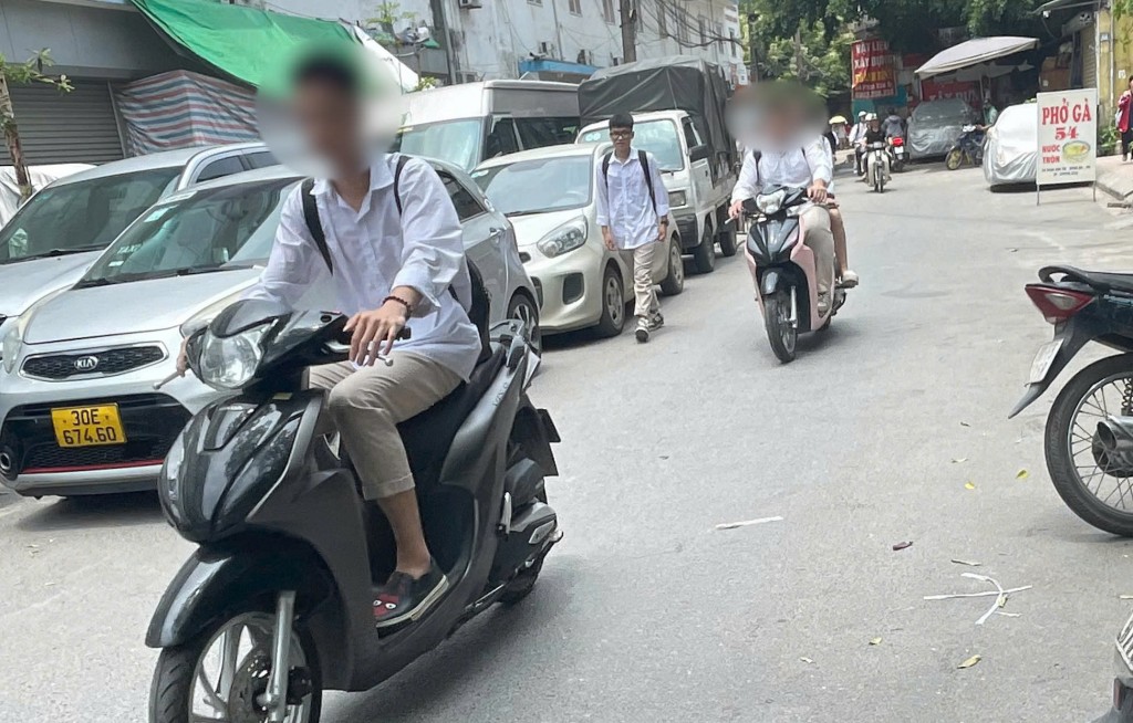 Nam sinh mặc đồng phục THPT điều khiển xe máy không đội mũ bảo hiểm trên đường Phan Văn Trị (Đống Đa, Hà Nội), dù chưa đủ tuổi theo quy định