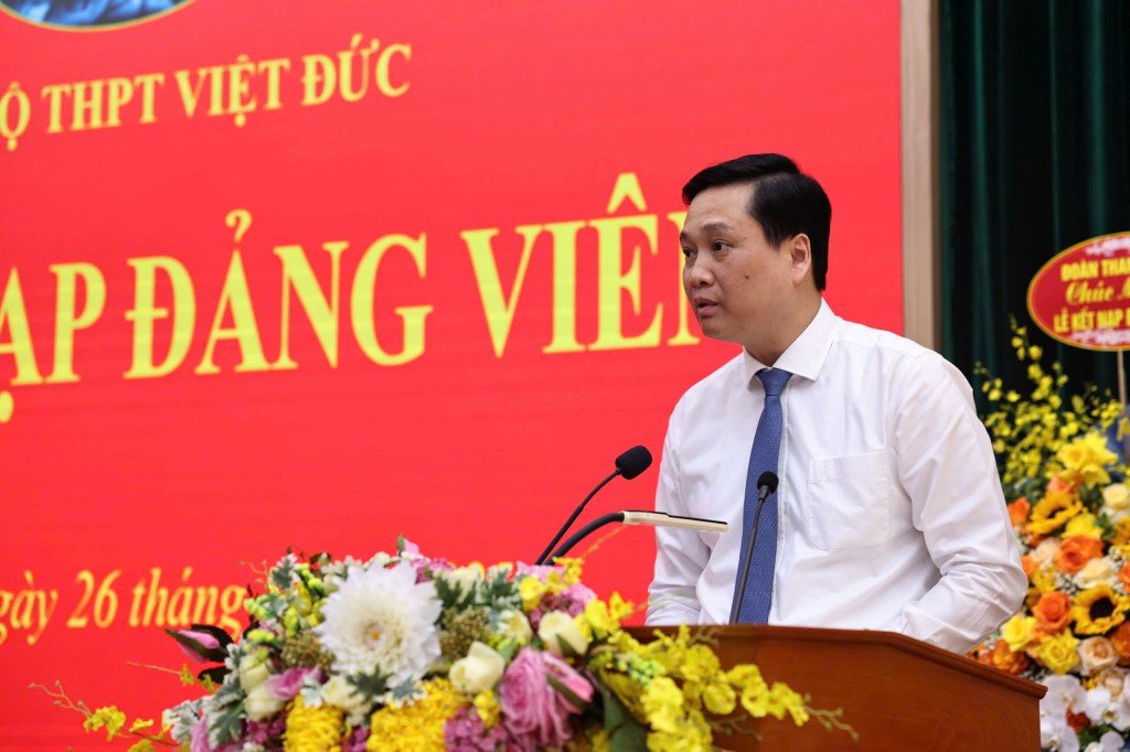 đồng chí Nguyễn Quốc Khánh - Phó Bí thư Thường trực Quận uỷ Hoàn Kiếm trao quyết định kết nạp Đảng cho các đảng viên trẻ. (Ảnh: Thanh Tùng)