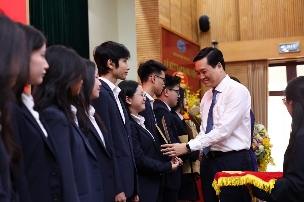 đồng chí Nguyễn Quốc Khánh - Phó Bí thư Thường trực Quận uỷ Hoàn Kiếm trao quyết định kết nạp Đảng cho các đảng viên trẻ. (Ảnh: Thanh Tùng)