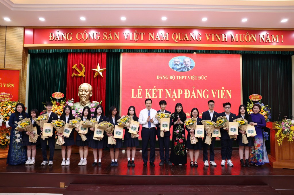 Lãnh đạo Quận uỷ và Ban Giám hiệu Trường THPT Việt Đức chúc mừng 12 đảng viên trẻ. (Ảnh: Thanh Tùng)
