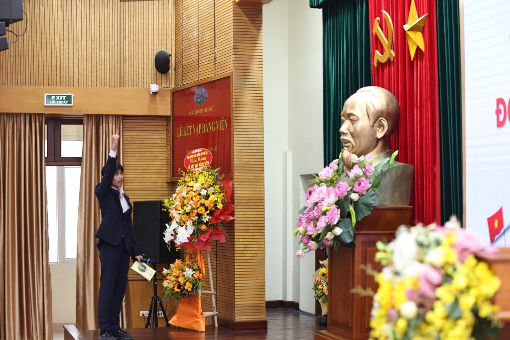 Đảng viên trẻ tuyên thệ trước cờ Tổ quốc, cờ Đảng và chân dung Chủ tịch Hồ Chí Minh. (Ảnh: Thanh Tùng)