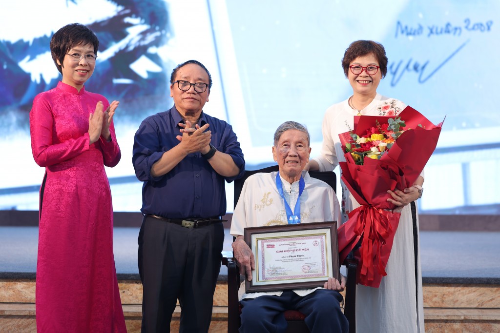 Tổng Giám đốc Thông tấn xã Việt Nam Vũ Việt Trang và Phó Chủ tịch Hội Nhà văn Việt Nam, Chủ tịch Hội đồng Giám khảo Giải thưởng Thiếu nhi Dế Mèn trao giải Hiệp sĩ Dế Mèn tới nhạc sĩ Phạm Tuyên 