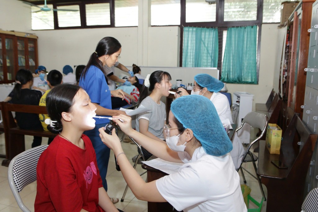Các bác sĩ khám chăm sóc răng miệng cho trẻ em