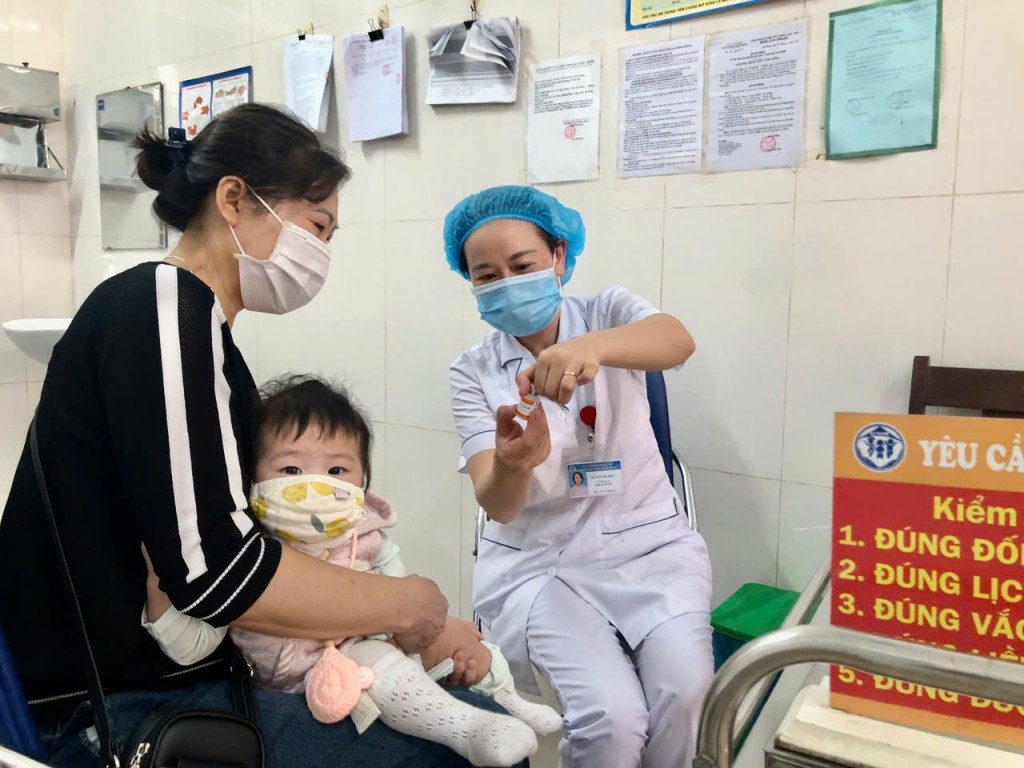 Người dân đưa trẻ đi tiêm chủng tại các trạm y tế