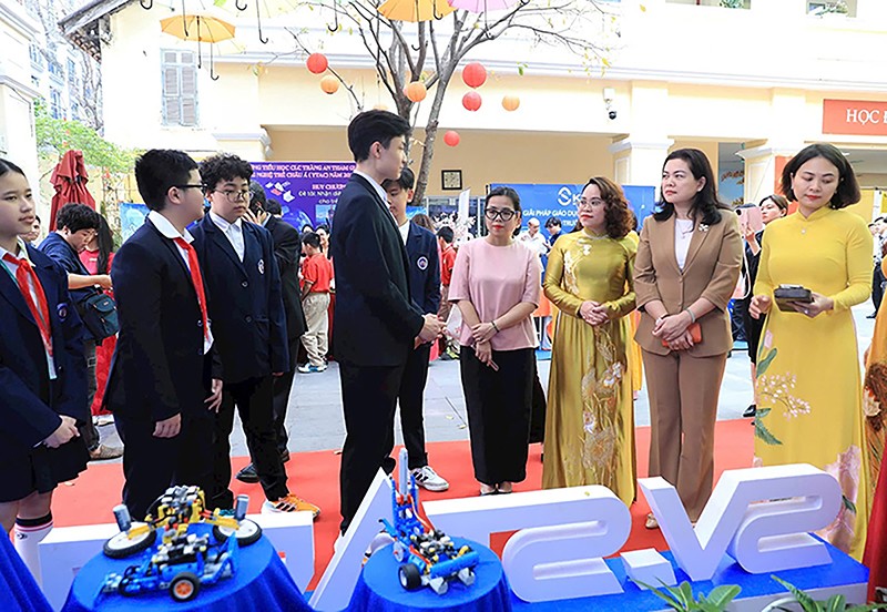 Các đại biểu nghe các em học sinh giới thiệu những phần mềm dự thi tại Tuần chuyển đổi số