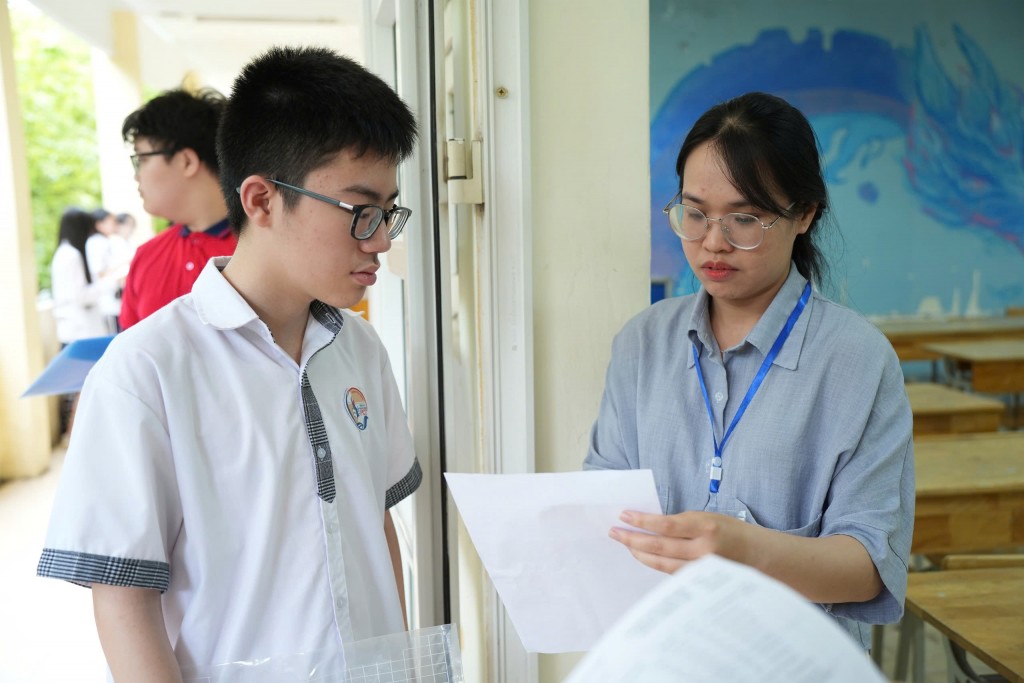 Giám thị kiểm tra, đối chiếu thông tin của thí sinh. Ảnh: Phạm Mạnh