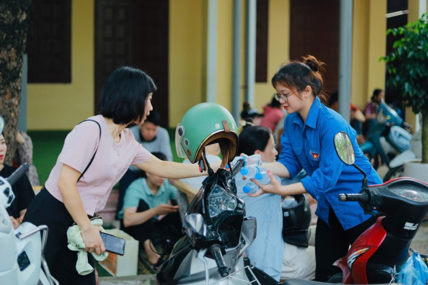 Tình nguyện viên trao tặng nước uống đến phụ huynh Tình nguyện viên trao tặng nước uống đến phụ huynh