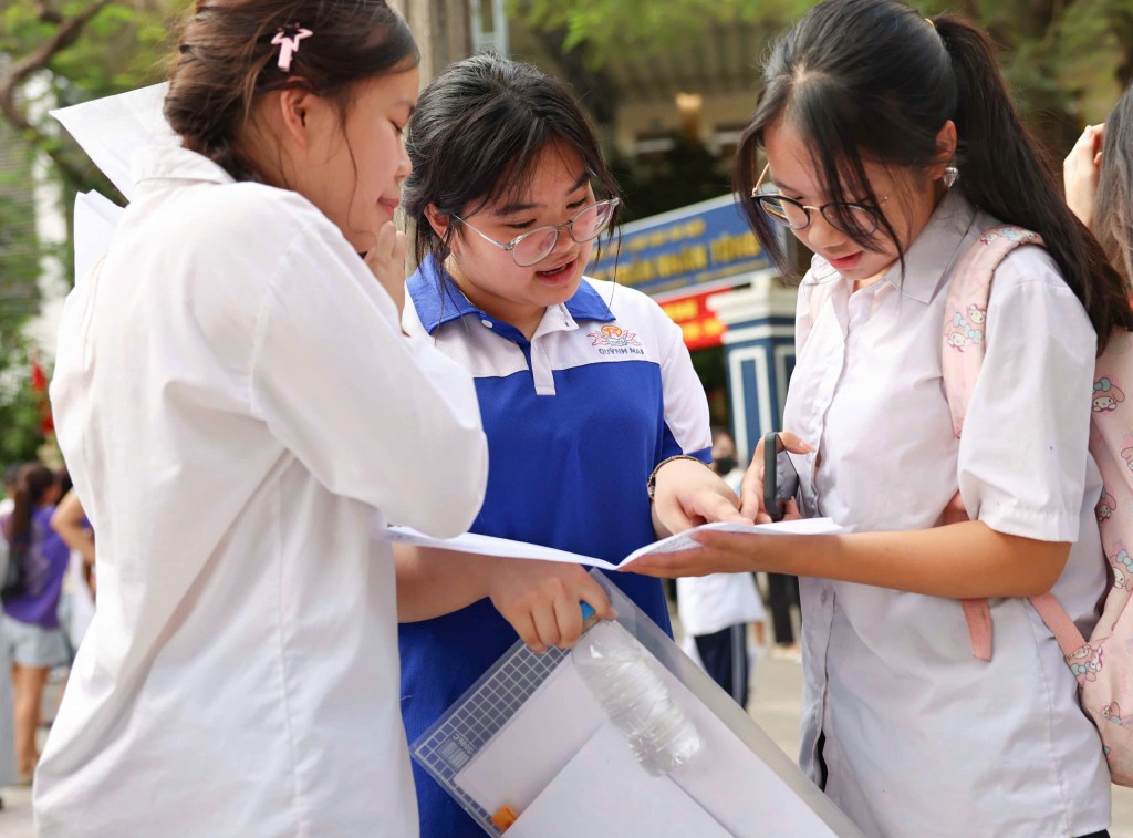 Các em tranh thủ trao đổi đáp án trước khi rời điểm thi. Ảnh: Đại Thắng
