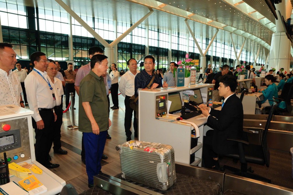 Phó Thủ tướng Trần Hồng Hà trò chuyện với hành khách, nhân viên tại một quầy làm thủ tục ở nhà ga T3 - Ảnh: VGP/Minh Khôi