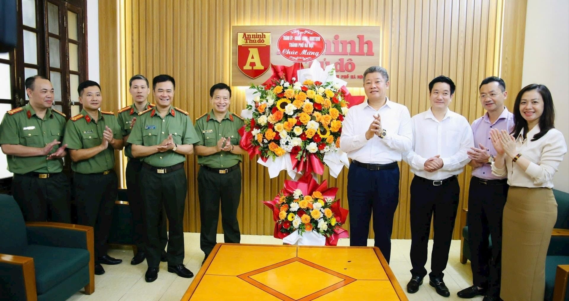 Phó Chủ tịch UBND thành phố Hà Nội Nguyễn Mạnh Quyền trao lẵng hoa chúc mừng các nhà báo Chuyên đề An ninh Thủ đô. Ảnh: Thu Minh