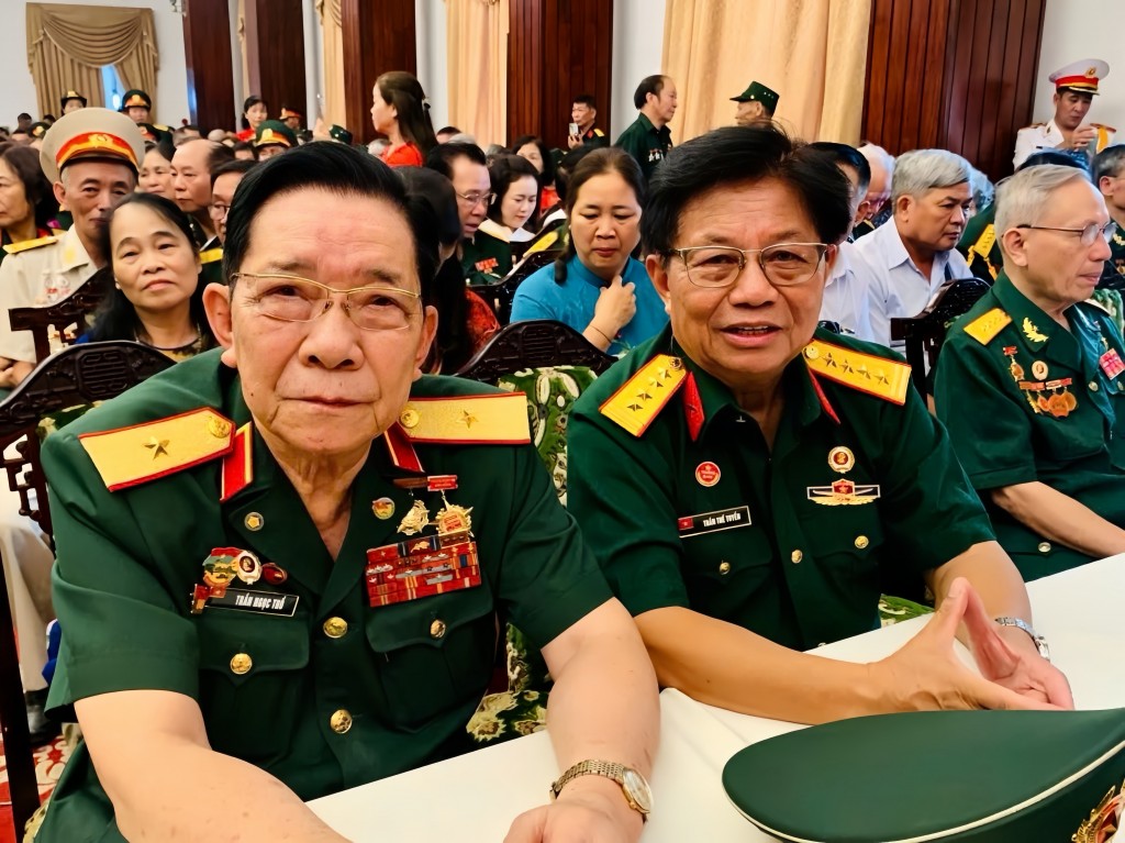 Nhà báo Trần Thế Tuyển (giữa) cùng các tướng lĩnh trong một cuộc gặp gỡ các chiến sĩ dịp kỷ niệm 50 năm Ngày Giải phóng miền Nam