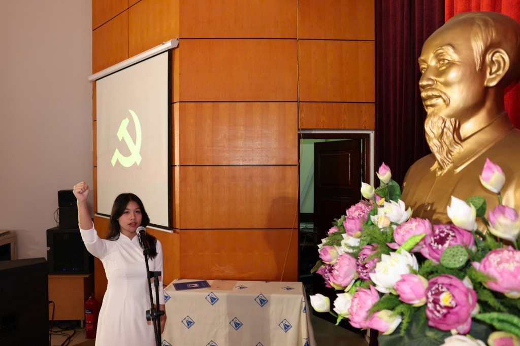 Tân đảng viên Nguyễn Tuyết Nhi tuyên thệ trước cờ Tổ quốc, cờ Đảng và chân dung Chủ tịch Hồ Chí Minh
