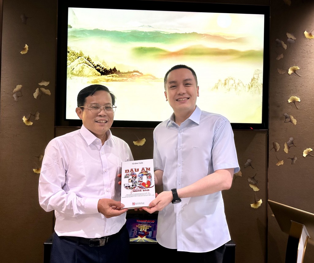 Nhà báo Tô Đình Tuân (bên trái) tặng sách nhà báo Lưu Quang Định, Nguyên TBT Báo Nông thôn Ngày nay/Dân việt.