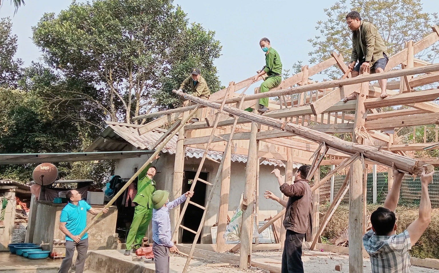 Lực lượng công an và cán bộ, công chức xã Ngọc Hội (huyện Chiêm Hóa, tỉnh Tuyên Quang) giúp đỡ người dân tháo dỡ nhà cũ, xây dựng nhà mới (Ảnh: Đỗ Sang)