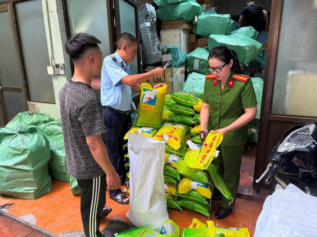 Lực lượng chức năng giám sát việc tiêu hủy yếu tố vi phạm quyền sở hữu công nghiệp đối với nhãn hiệu gạo ST25. Ảnh: Minh Tùng