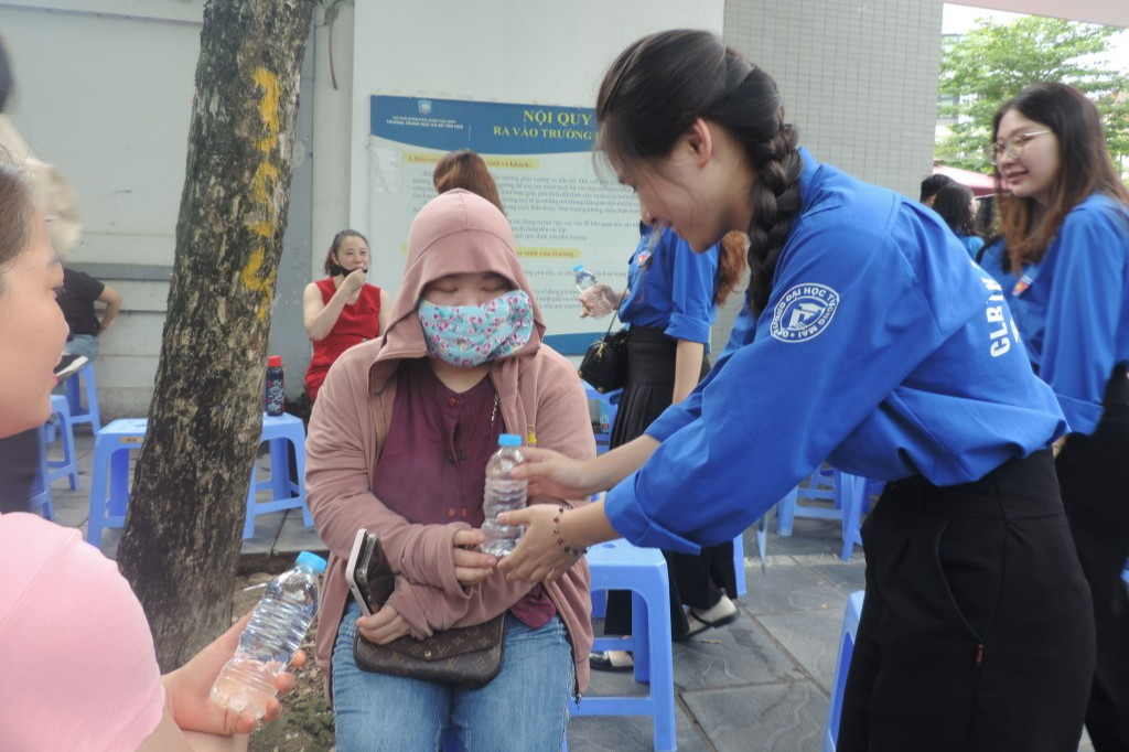 Tình nguyện viên trao tặng nước đến phụ huynh 