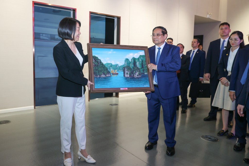 Thủ tướng tặng quà lưu niệm cho đại diện lãnh đạo Phòng Triển lãm phát triển và mở cửa Phố Đông Thượng Hải - Ảnh: VGP/Nhật Bắc