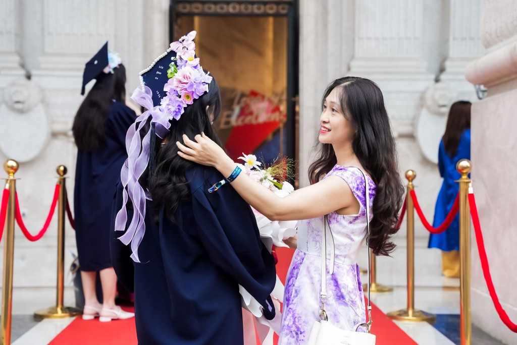 Phụ huynh chuẩn bị lễ phục cho tân khoa trước buổi lễ Phụ huynh chuẩn bị lễ phục cho tân khoa trước buổi lễ