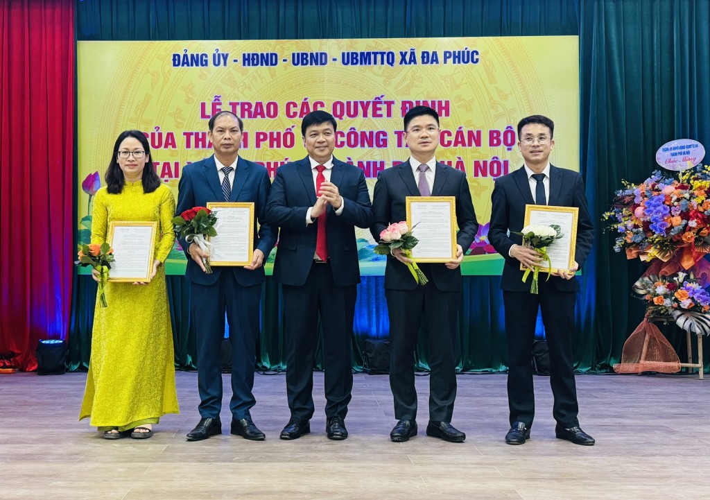 đồng chí Nguyễn Chí Lực TUV - Phó Chủ nhiệm Ủy ban Kiểm tra Thành ủy lên trao Quyết định và tặng hoa chúc mừng các đồng chí trong Hội đồng Nhân dân xã Đa Phúc