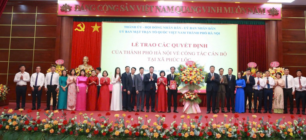 Đồng chí Nguyễn Mạnh Quyền, Phó Chủ tịch UBND thành phố Hà Nội trao các quyết định và tặng hoa về công tác cán bộ xã Phúc Lộc