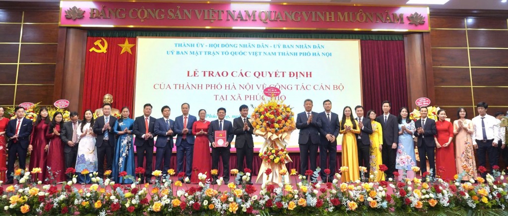 Đồng chí Nguyễn Mạnh Quyền, Phó Chủ tịch UBND thành phố Hà Nội trao các quyết định và tặng hoa về công tác cán bộ xã Phúc Thọ