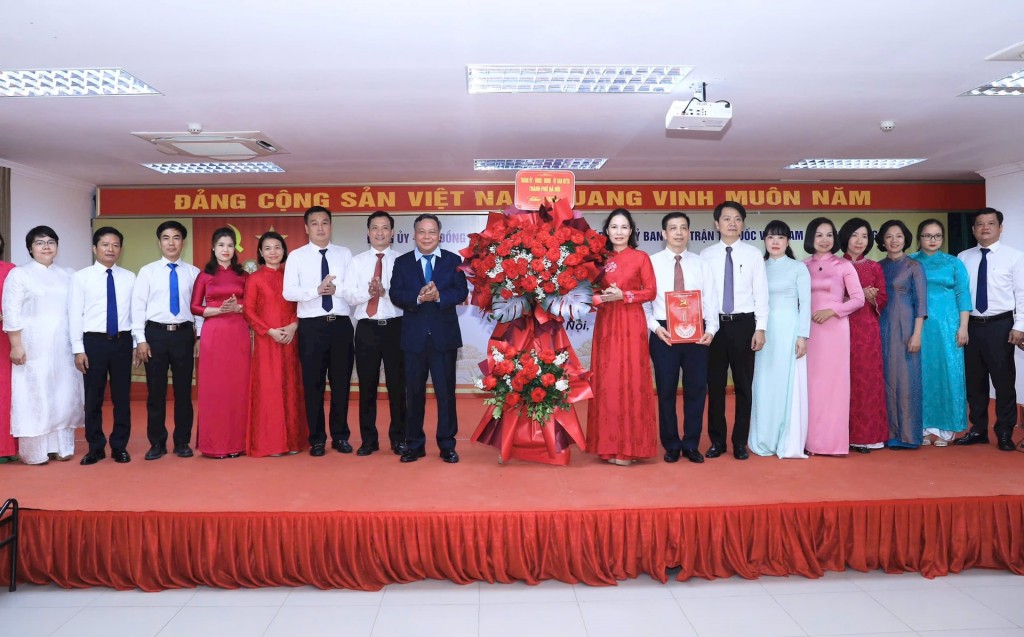 Phó Bí thư Thường trực Thành ủy Hà Nội Nguyễn Văn Phong trao quyết định và tặng hoa chúc mừng Ban Chấp hành Đảng bộ phường Dương Nội. Ảnh: Quang Thái