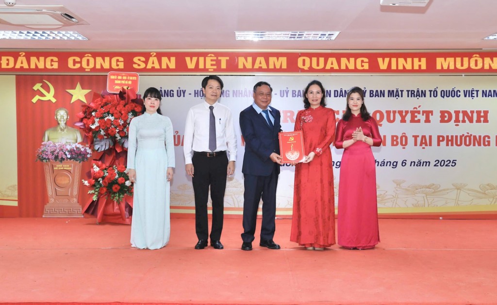 Phó Bí thư Thường trực Thành ủy Hà Nội Nguyễn Văn Phong trao quyết định về công tác cán bộ cho tập thể lãnh đạo HĐND phường Dương Nội. Ảnh: Quang Thái