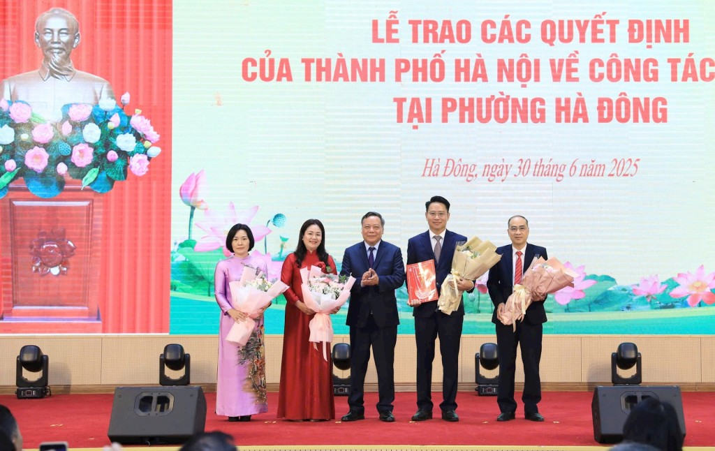 Phó Bí thư Thường trực Thành ủy Hà Nội Nguyễn Văn Phong trao quyết định công tác cán bộ và tặng hoa chúc mừng lãnh đạo HĐND phường Hà Đông. Ảnh: Quang Thái