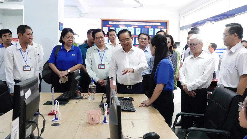 Chủ tịch Nguyễn Văn Được trao đổi với các tình nguyện viên hướng dẫn thủ tục hành chính . (Ảnh: Sỹ Đông)