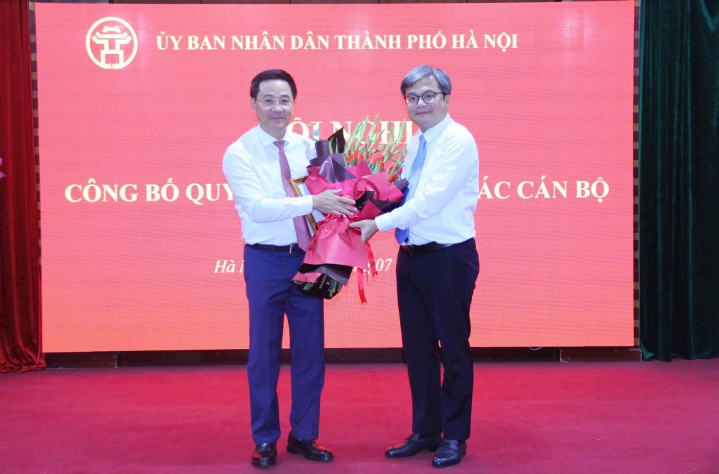 Phó Chủ tịch UBND thành phố Trương Việt Dũng trao quyết định bổ nhiệm và tặng hoa tân Giám đốc Sở Khoa học và Công nghệ Trần Anh Tuấn. Ảnh: Đỗ Minh