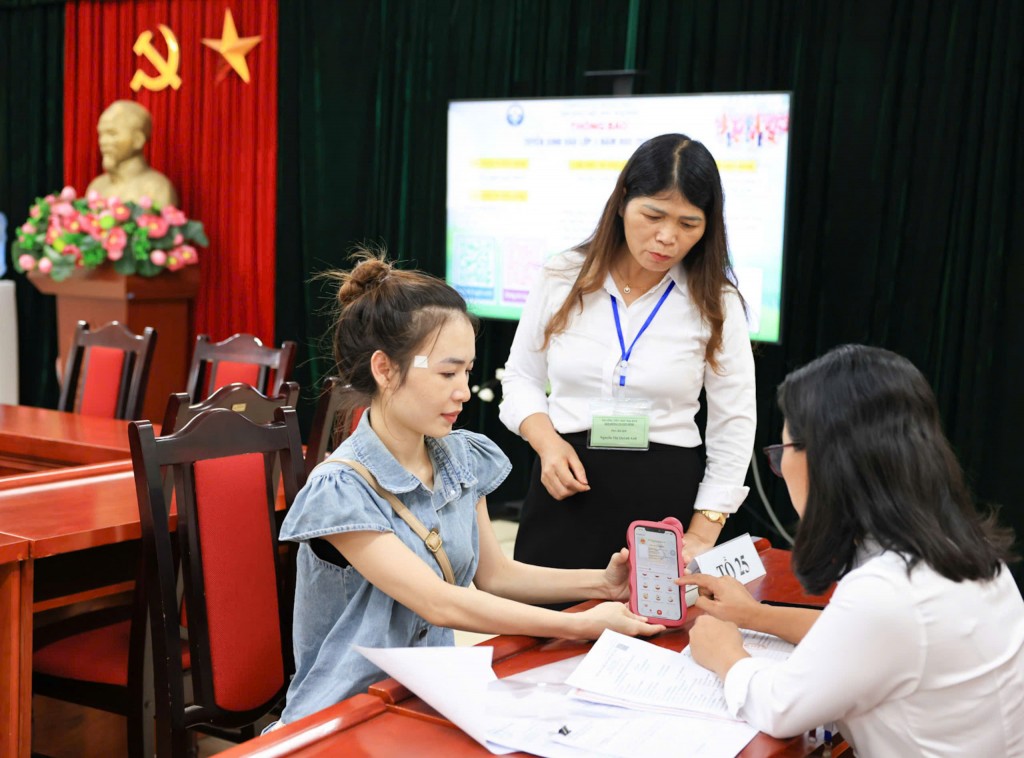 Sau khi hoàn thành tuyển sinh trực tuyến, phụ huynh trẻ đến trường hoàn tất thủ tục trực tiếp cho con. Ảnh: Đại Thắng