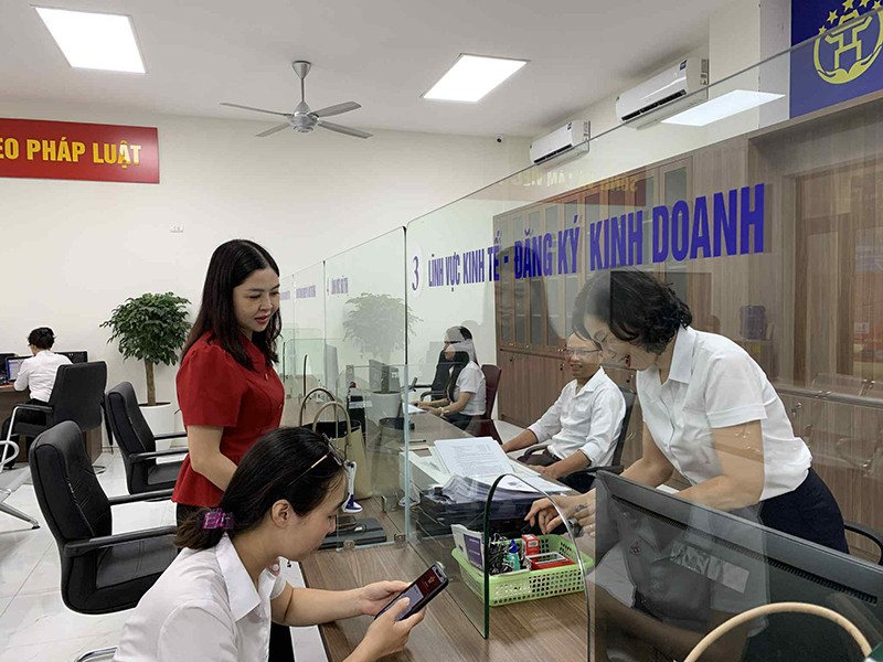 Đồng chí Phó Bí thư Thường trực Đảng uỷ phường Đại Mỗ Nguyễn Thị Hoài Thu (áo đỏ) trao đổi công việc với cán bộ một cửa 