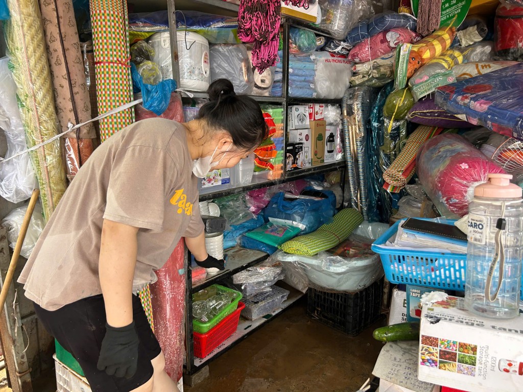 Tiểu thương Nguyễn Ly chỉ về vị trí mực nước ngập đêm qua (Ảnh Đ.Minh)