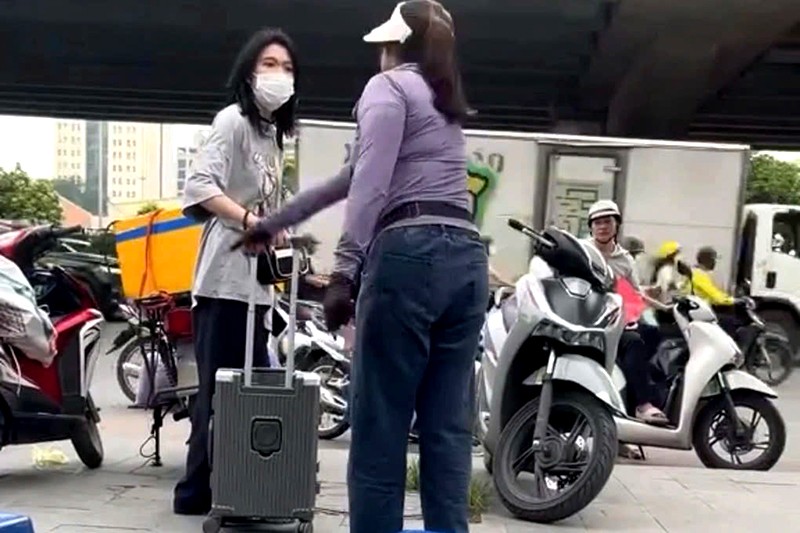 Nội dung hình ảnh clip người phụ nữ bán trà đá xua đuổi cô gái trẻ đứng trên vỉa hè